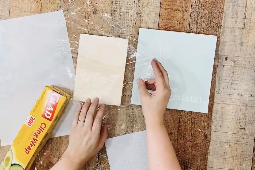 placing plastic wrap on a wood block