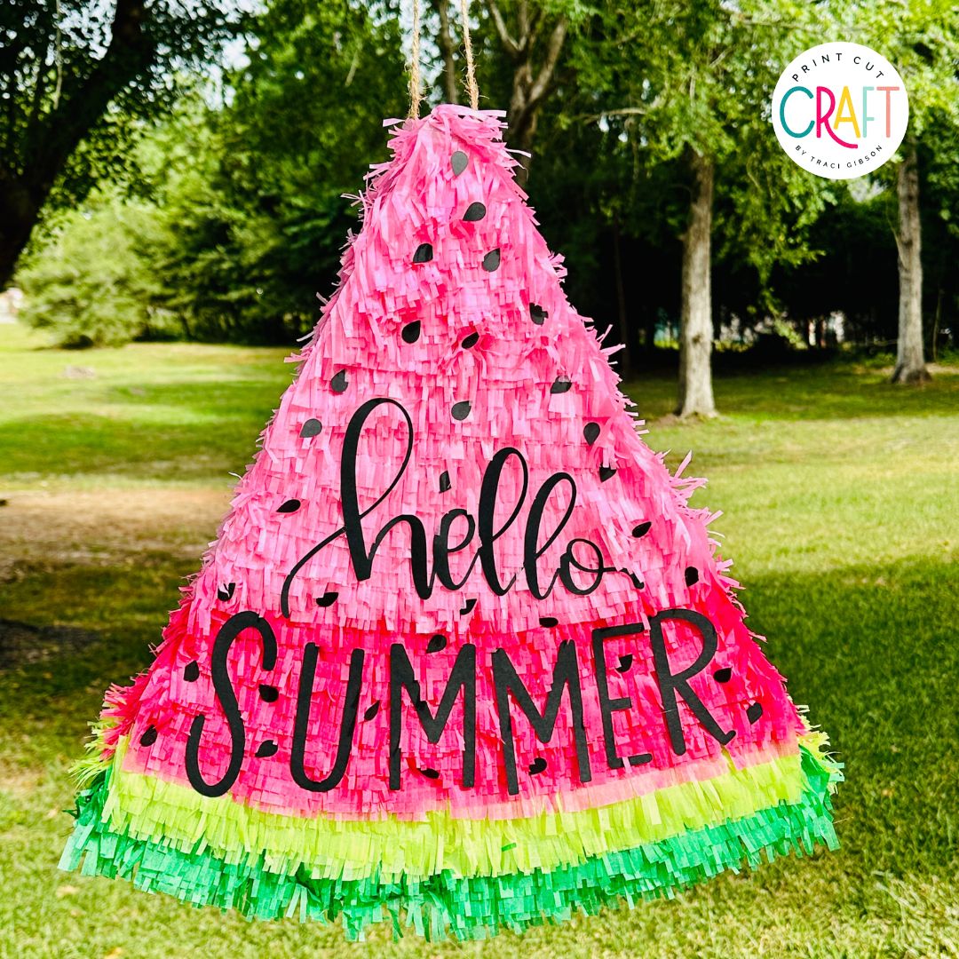 watermelon pinata hanging from a tree made with a cricut machine.